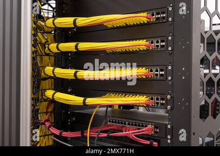 Close up on neat and tidy patched network cables, RJ45, connected to the switches and routers mounted on the rack in data centre, networking Stock Photo
