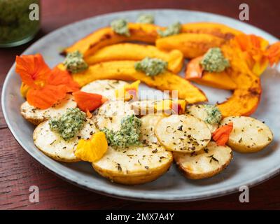 Roasted Winter Squash and New Potatoes with Nasturtium Pesto Stock Photo