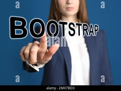 Businesswoman touching virtual screen with word BOOTSTRAP against blue background, focus on hand Stock Photo