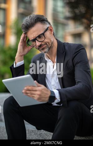 A businessman in eyeglasses looking serious and confused Stock Photo