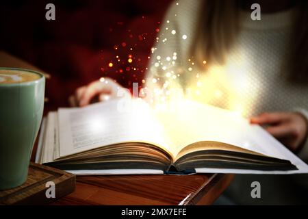 Woman reading shiny magic book, closeup view Stock Photo