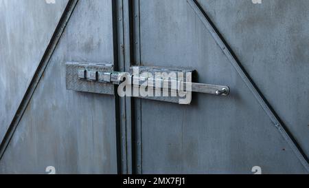 Old gray metal gate with a deadbolt. The bolt is locked. Traces of corrosion on a metal surface. Aging process. Rust. Home security. Outdoors Stock Photo