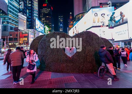 Tourists crowd “Love's h|Edge”, the winner of the 15th Annual Times Square Love & Design Competition in Times Square in New York on Wednesday, February 1, 2023. Designed by Almost Studio, the Valentine’s Day sculpture consists of heart-shaped “hedges” giving visitors a maze-like secret garden, and lots of selfie opportunities. The sculpture will be on display through February 28.(© Richard B. Levine) Stock Photo