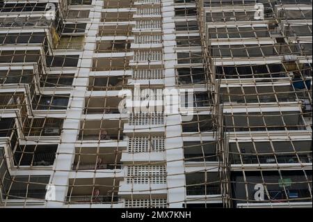 INDIA, Mumbai, apartment tower under renovation, Scaffolding with bamboo poles tied with jute ropes / INDIEN, Mumbai, Wohnhaus mit Baugerüst aus Bambus Stock Photo