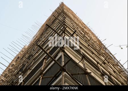 INDIA, Mumbai, apartment tower under renovation, Scaffolding with bamboo poles tied with jute ropes / INDIEN, Mumbai, Wohnhaus mit Baugerüst aus Bambus Stock Photo