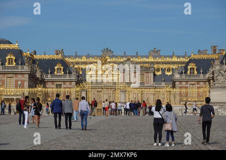 France, Versailles, Panorama picture of the famous Palace of Versailles near the golden royal gate where visitors are queuing at the entrance in the c Stock Photo