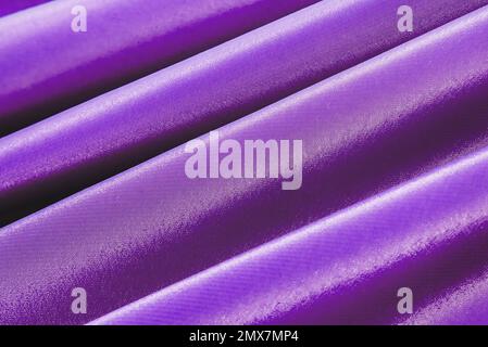 The texture of a luxurious smooth fabric in blue with folds and waves. Blue, purple fabric, material Stock Photo