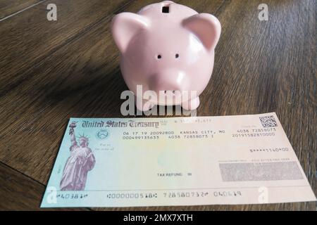 Tax refund check with pink piggy bank Stock Photo