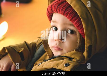 A young white Caucasian boy wearing thick winter clothes looking directly at the camera Stock Photo