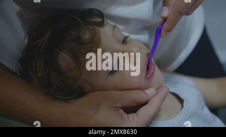 Parent brushing child teeth at night routine before bedtime. Mother brushes little boy teeths with toothbrush. closeup mouth Stock Photo