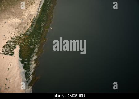 A high angle overhead view of a boat moored on the sandy banks of the Irrawaddy River in Myanmar (Burma). Stock Photo