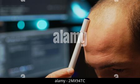 Pensive programmer brainstorming ideas to create user interface, thinking about algorithm and html server code. Being thoughtful about artificial intelligence. Handheld shot. Close up. Stock Photo