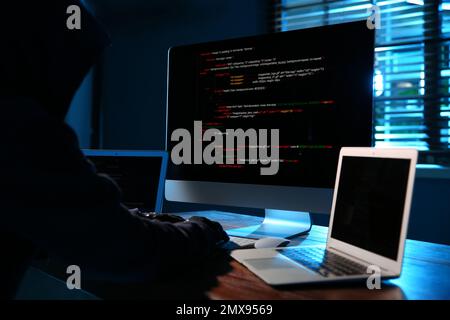 Hacker with computers in dark room. Cyber crime Stock Photo