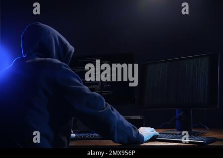 Hacker with computers in dark room. Cyber crime Stock Photo