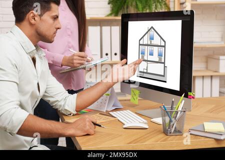 Engineers at work. Colleagues projecting house in office Stock Photo