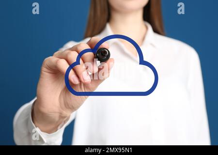 Woman pointing at virtual cloud icon on blue background, closeup of hand. Data storage concept Stock Photo