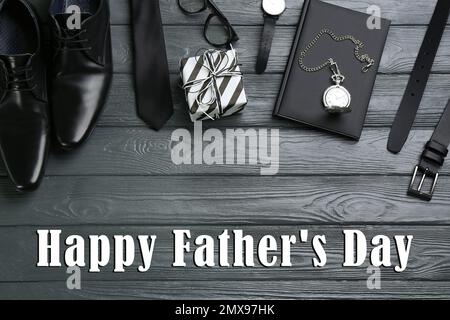 Flat lay composition with male accessories and phrase HAPPY FATHER'S DAY on grey wooden background Stock Photo