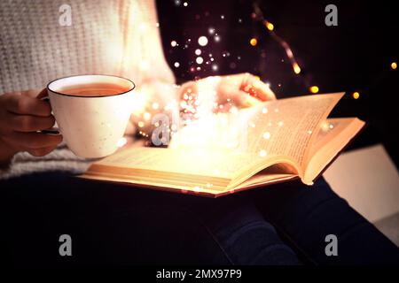 Woman reading shiny magic book, closeup view Stock Photo