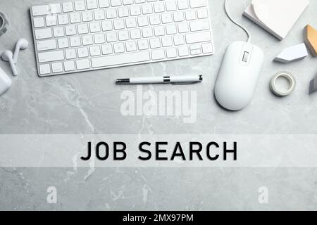 Flat lay composition with computer mouse and keyboard on light grey marble table. Job search Stock Photo