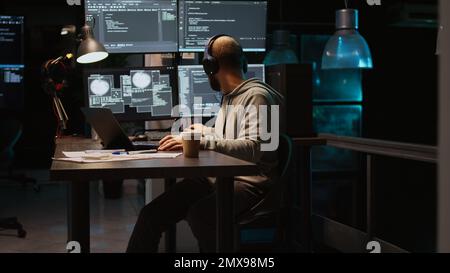 Database programmer writing html code on multiple screens, displaying cloud computing algorithm at night. Programming online network with coding language to develop new interface. Handheld shot. Stock Photo