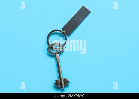 Key with metallic keychain on color background Stock Photo