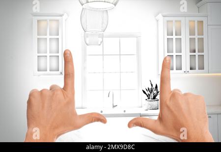 Woman showing frame gesture and making kitchen real out of drawing Stock Photo