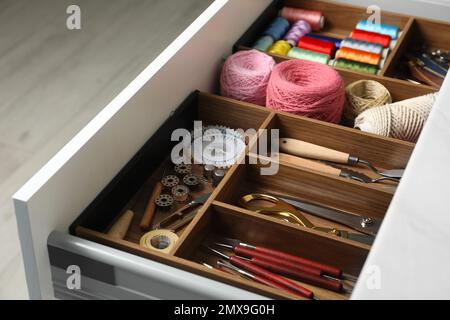 Sewing accessories in open desk drawer indoors Stock Photo