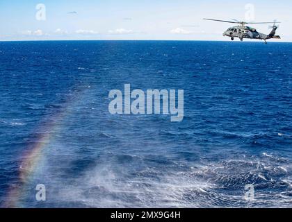 230131-N-IX644-1195 ADRIATIC SEA (Jan. 31, 2023) An MH-60S Nighthawk helicopter, attached to Helicopter Sea Combat Squadron (HSC) 5, flies alongside the Nimitz-class aircraft carrier USS George H. W. Bush (CVN 77) during flight operations, Jan. 31, 2023. Carrier Air Wing (CVW) 7 is the offensive air and strike component of Carrier Strike Group (CSG) 10, George H.W. Bush CSG. The squadrons of CVW-7 are Strike Fighter Squadron (VFA) 86, VFA-103, VFA-136, VFA-143, Electronic Attack Squadron (VAQ) 140, Carrier Airborne Early Warning Squadron (VAW) 121, HSC-5, and Helicopter Maritime Strike Squadro Stock Photo