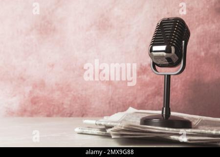 Newspapers and vintage microphone on table, space for design. Journalist's work Stock Photo