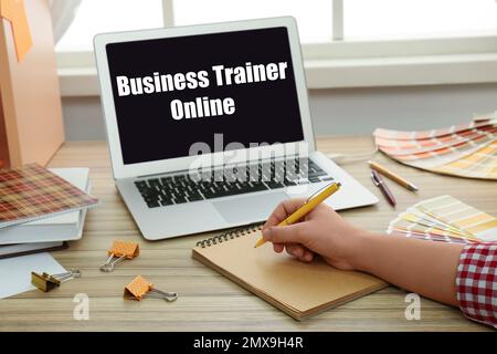 Woman working with laptop at wooden table, closeup. Business trainer online Stock Photo