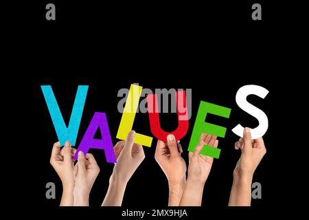 People making word VALUES of letters on black background Stock Photo