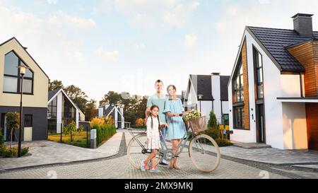 Happy family smiling near their new house Stock Photo