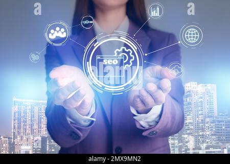 Woman demonstrating directions of SEO. Icons of keyword research, customization and others Stock Photo