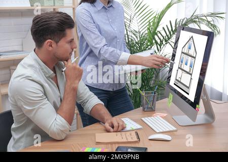 Engineers at work. Colleagues projecting house in office Stock Photo