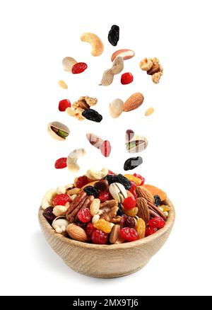 Different nuts falling into bowl on white background Stock Photo