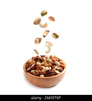 Different nuts falling into bowl on white background Stock Photo