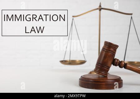 Judge's gavel, scales and words IMMIGRATION LAW on light background Stock Photo