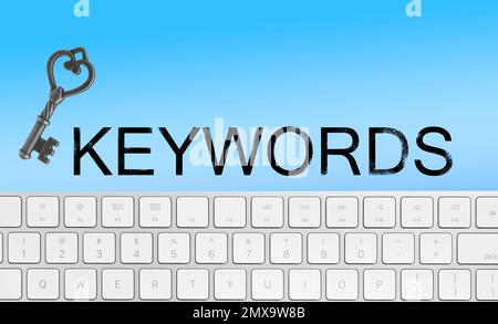 Word Keywords, computer keyboard and key on light blue background. SEO direction Stock Photo