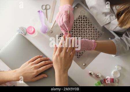 Professional manicurist working with client in beauty salon, top view Stock Photo