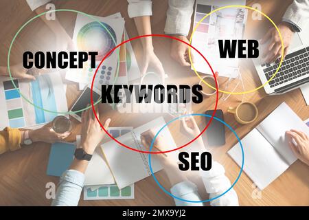Keywords research concept. Team of SEO specialists working at table, top view Stock Photo
