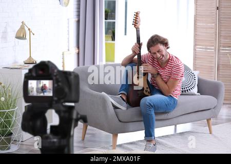 Music teacher recording guitar lesson at home Stock Photo