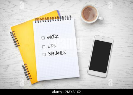 Work-life balance concept. Flat lay composition with notebooks, smartphone and cup of coffee on light background Stock Photo