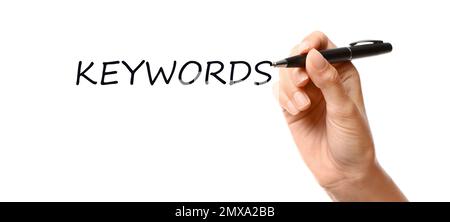 Woman writing word KEYWORDS on transparent board against white background, closeup Stock Photo