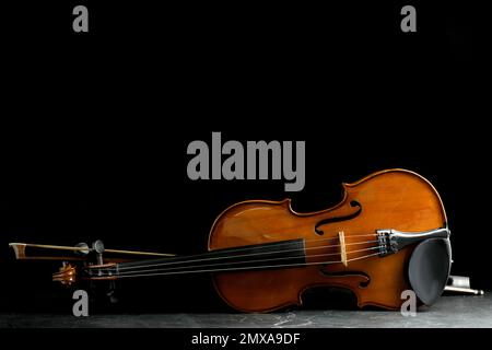 Classic violin and bow on grey stone table. Space for text Stock Photo