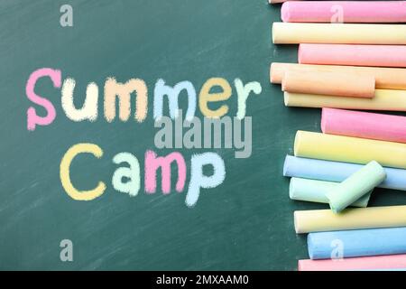 Pieces of color chalk and stationery on table near blackboard with text  School's Out. Summer holidays Stock Photo - Alamy