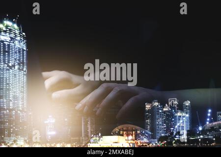 Double exposure of female programmer using laptop and cityscape, closeup Stock Photo