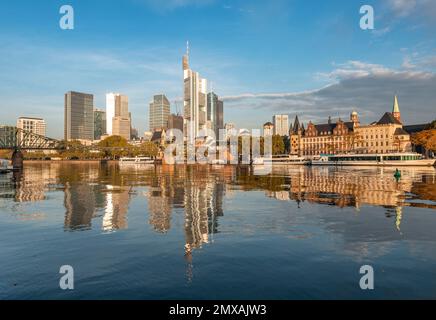 Excursion boats on the river bank, view over the Main, skyline reflected in the river, skyscrapers in the banking district in the morning light Stock Photo