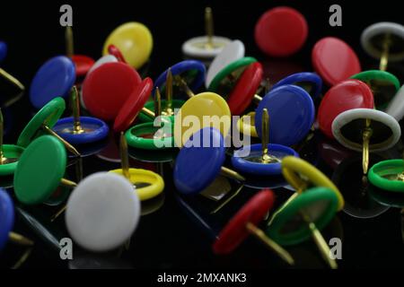 multicolored tacks isolated on black background Stock Photo