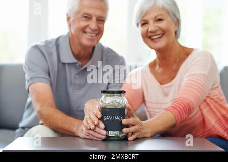 Finally we can take the vacation of our dreams. Happy couple looking pleased with their savings so far. Stock Photo