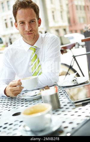 Meeting with a client during lunch. A young businessman drinking coffee at an outdoor cafe. Stock Photo